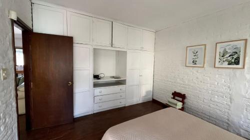 a bedroom with a bed and white cabinets at Casa cabaña in Paysandú