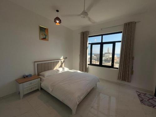 1 dormitorio con cama y ventana grande en Tiwi Pearl, en Sur