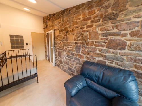 a leather couch in a room with a brick wall at Magnificent holiday home with hot tubs in Esneux