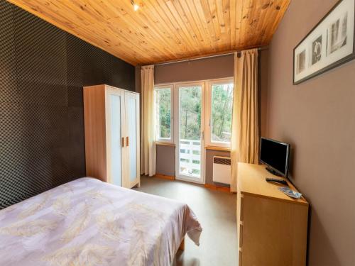 Schlafzimmer mit einem Bett und einem Schreibtisch mit einem Computer in der Unterkunft Magnificent accommodation for 7 travellers with hot tubs in Esneux