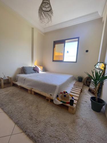 um quarto com uma cama com uma estrutura em madeira em Private and cosy room in a shared apartment em Agadir