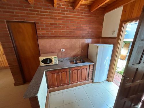 a small kitchen with a refrigerator and a microwave at Urú in Puerto Iguazú