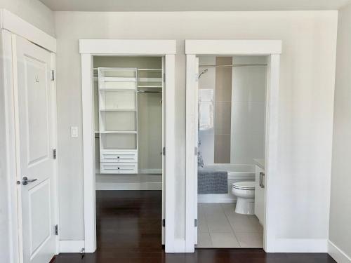 a white bathroom with a toilet and a bath tub at Spacious Home in Richmond in Richmond