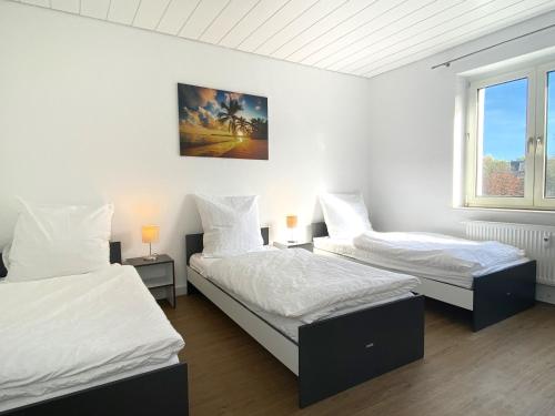 - 2 lits dans une chambre aux murs blancs dans l'établissement Meribu L92 Wohnung für Monteure und Arbeiter, à Essen