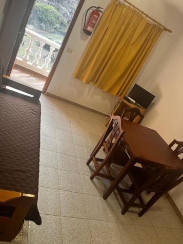 - une table et des chaises dans une chambre avec fenêtre dans l'établissement Apartamentos la Fajana, à Barlovento