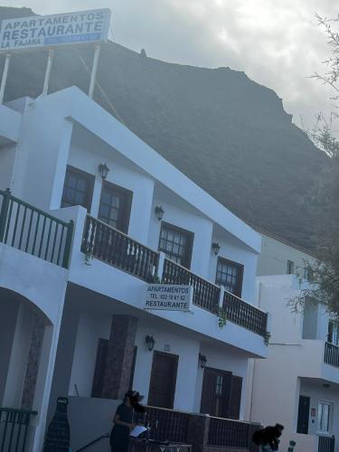 Un bâtiment blanc avec des personnes debout devant lui dans l'établissement Apartamentos la Fajana, à Barlovento