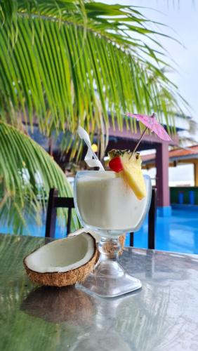 a drink in a martini glass sitting on a table at Hotel Partenon Beach in La Ceiba