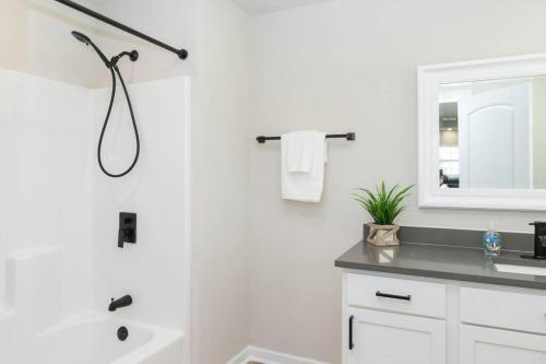a white bathroom with a shower and a sink at Bayou Retreat-Located on Tranquill Bayou Lafourche in Thibodaux
