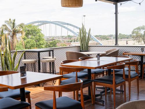 a restaurant with tables and chairs and a view of a bridge at Rua Hoteles Piura in Piura