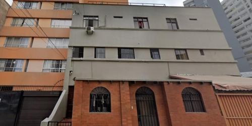 een hoog gebouw met ramen en een bakstenen gebouw bij Hospedaje Miraflores 17 in Lima