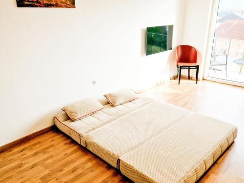 łóżko w pokoju z czerwonym krzesłem w obiekcie Apartment in Fohnsdorf near thermal baths w mieście Fohnsdorf