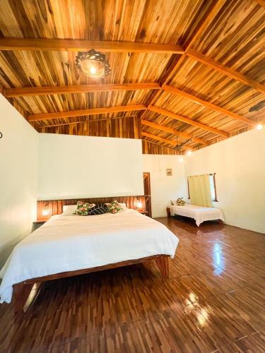 een slaapkamer met een bed en een houten plafond bij Ficus house in Boca Tapada