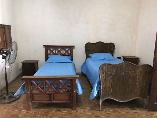 1 dormitorio con 2 camas, mesa y sillas en La casona de San José en Cachí
