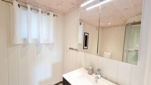 a white bathroom with a sink and a mirror at Holiday cabin in beautiful surroundings in Vradal
