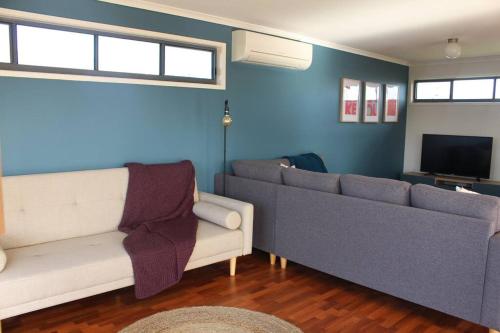 Una sala de estar con un sofá y un televisor. en Beach Hideaway, en Sunset Strip