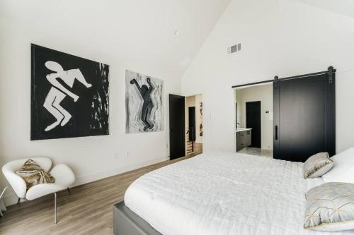 a white bedroom with a large bed and a chair at 25% OFF Weekly New Cozy 4B EVcharger Gym The Haus in Austin