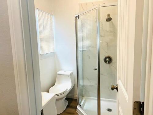 a bathroom with a toilet and a glass shower at The Chadwick in San Diego