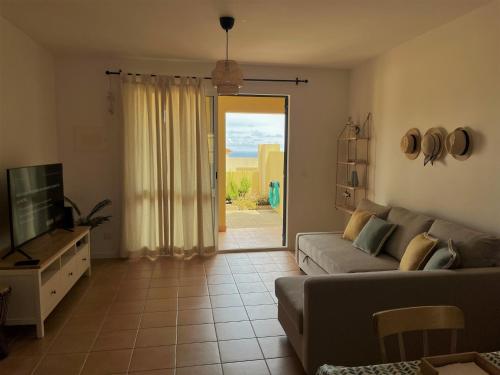 a living room with a couch and a sliding glass door at Porto Santo Happy Place in Porto Santo