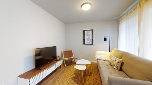 ein Wohnzimmer mit einem Sofa und einem Flachbild-TV in der Unterkunft Hazel's Hideaway apt in walkable historic area in Snohomish