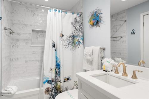 a white bathroom with a sink and a shower curtain at 4409 Ocean Pointe in Tavernier