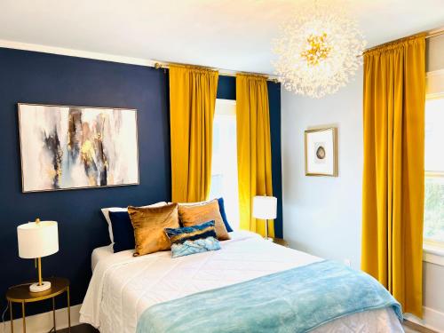 a bedroom with a bed with blue walls and yellow curtains at The Chadwick in San Diego