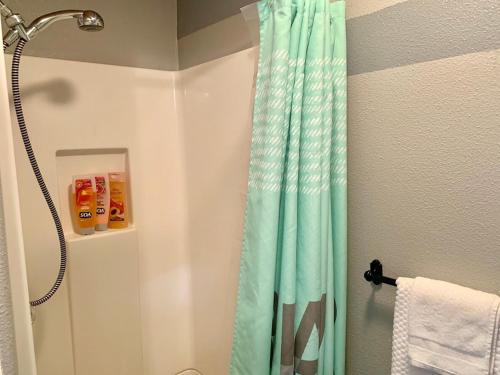 a shower with a blue shower curtain in a bathroom at The Chadwick in San Diego