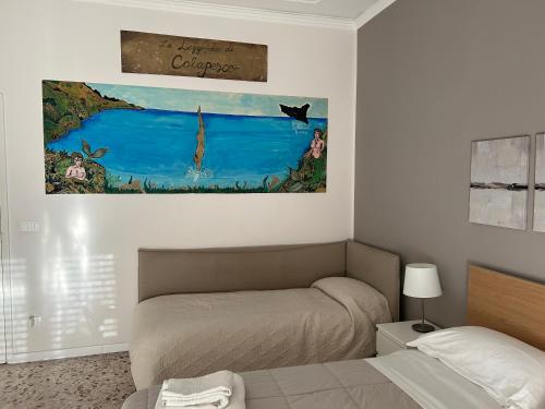 um quarto com uma cama e um quadro na parede em Giuffrida Apartment Rooms em Catânia