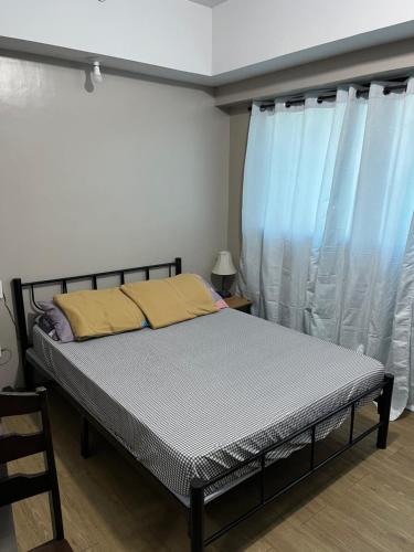 un letto in una camera con tende blu di Fernando's Studio Pad At Monte Carlo With Broadband & Netflix! a Manila