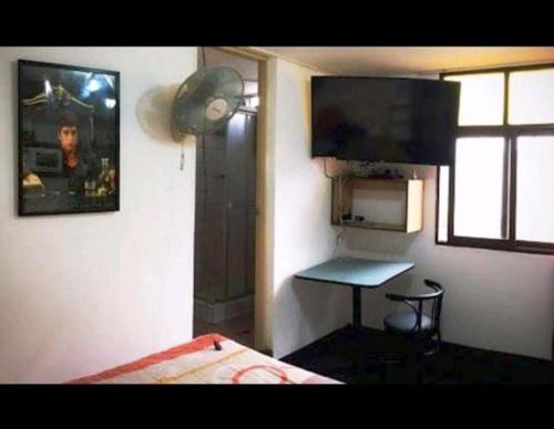 um quarto com uma cama, uma mesa e uma janela em Hospedaje Miraflores 17 em Lima