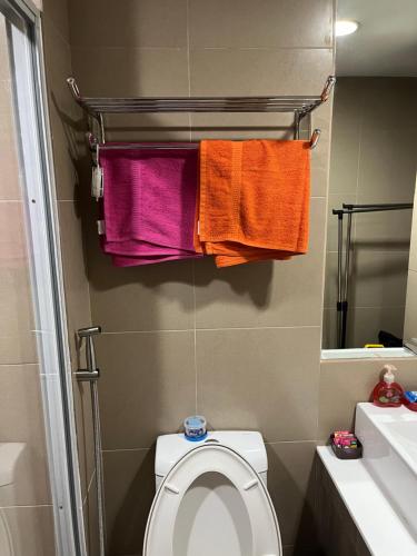 bagno con asciugamani appesi ai servizi igienici di Fernando's Studio Pad At Monte Carlo With Broadband & Netflix! a Manila