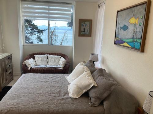 1 dormitorio con cama y ventana con sofá en ALOJAMIENTO FRENTE AL MAR, CONDOMINIO BAHIA PELICANOS, en Puchuncaví