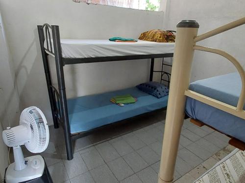 a bunk bed in a room with a fan at Quarto bem próximo ao Pelourinho in Salvador