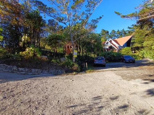 a driveway with cars parked in front of a house at Hotel Claro de Luna in Monteverde Costa Rica