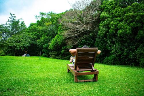 a person sitting in a chair in a field of grass at Hotel Claro de Luna in Monteverde Costa Rica