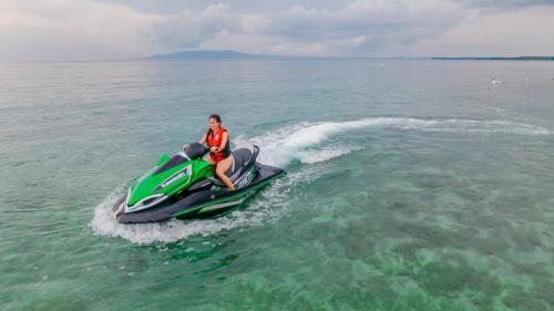 a man riding a jet ski in the water at Modala Beach Resort in Panglao