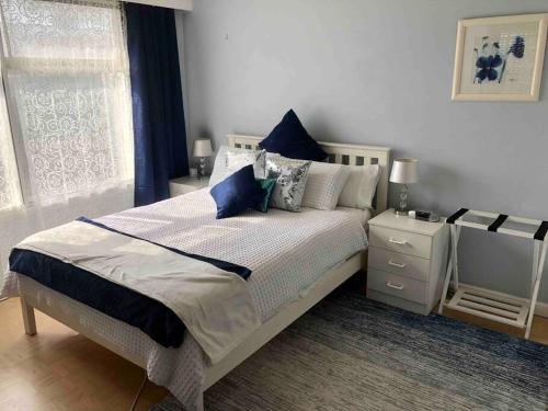 een slaapkamer met een groot bed met blauwe kussens bij BEACH Living - “A bit of Mykonos near Mordialloc!” in Aspendale