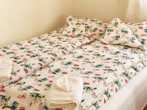 a bed with a flowery comforter and pillows on it at Holiday home Nordfold in Nordfold