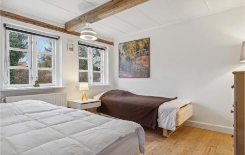 - une chambre avec 2 lits et 2 fenêtres dans l'établissement Amazing Home In Kirke Sby With Kitchen, à Kirke Såby