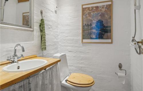 Baño blanco con aseo y lavamanos en Amazing Home In Kirke Sby With Kitchen en Kirke Såby