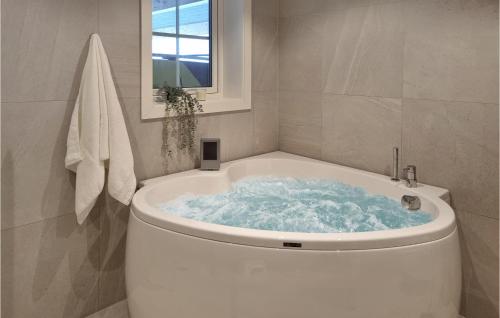 a white bath tub in a bathroom with a window at Gorgeous Home In seral With Kitchen in Åseral