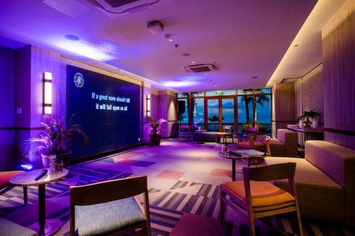 a restaurant with tables and chairs and a large screen at Modala Beach Resort in Panglao