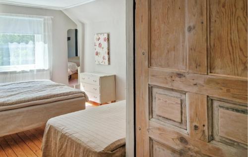 - une chambre avec 2 lits et une porte en bois dans l'établissement 1 Bedroom Nice Apartment In Ljungbyhed, à Ljungbyhed