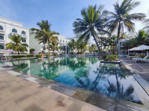 una piscina en un complejo con palmeras en Stella Marina Boutique Hotel en Phu Quoc