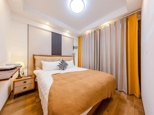 a bedroom with a large bed and a desk at Annie 公寓-2602 in Kunming