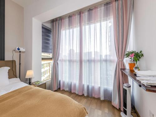 um quarto com uma cama e uma grande janela em Annie 公寓-2602 em Kunming