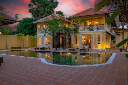 a house with a pool in front of it at Ptas Songsaa by Amatak in Siem Reap