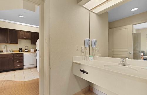 a kitchen with a sink and a counter with a mirror at Resort Hotel Condo near Disney parks - Free parks shuttle in Orlando