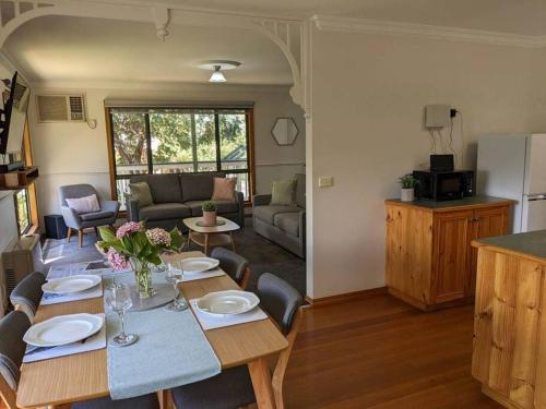 a dining room and living room with a table at Buninyong Country Cottage in Buninyong