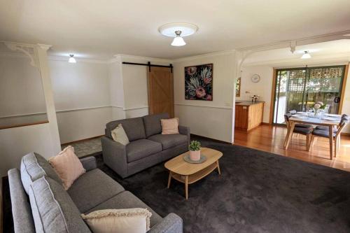 a living room with a couch and a table at Buninyong Country Cottage in Buninyong