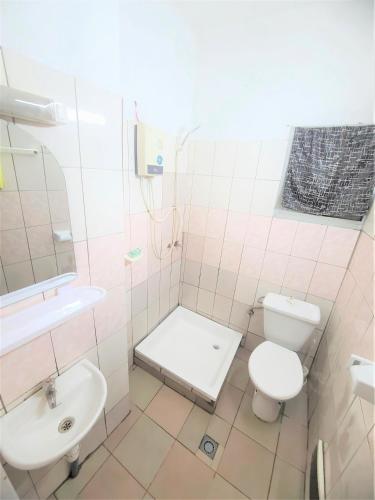 a white bathroom with a toilet and a sink at The Yafé Bastos 1 in Yaoundé
